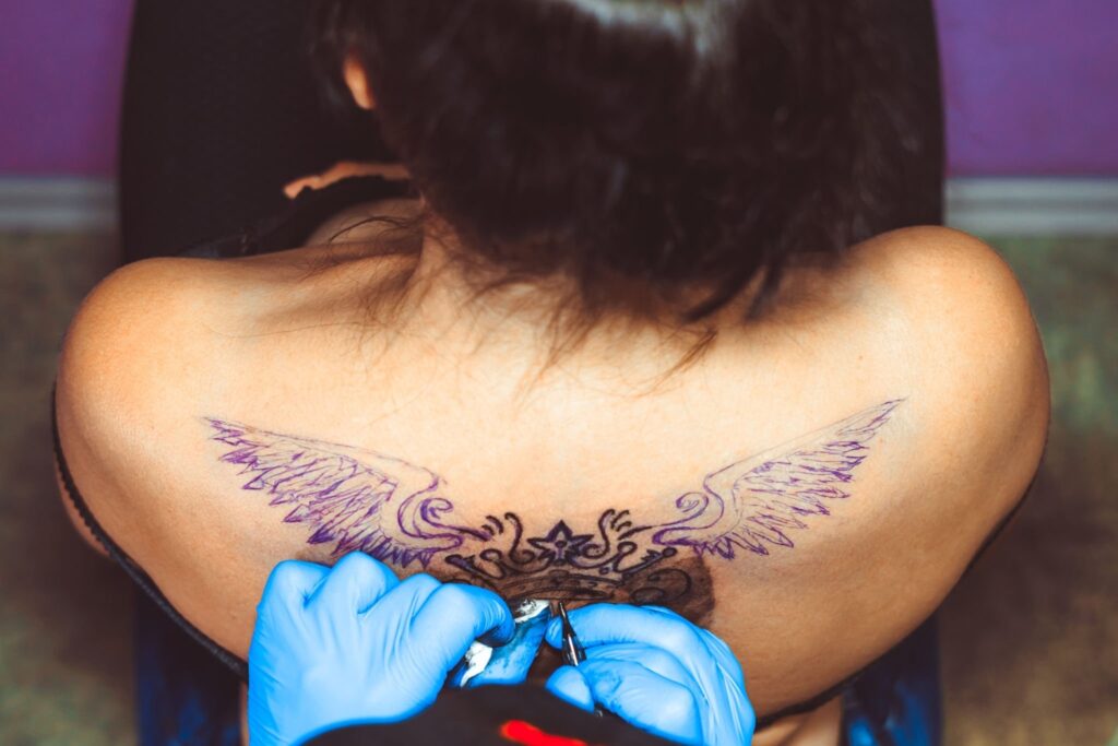 Wings tattoo on the angle for girls photo.