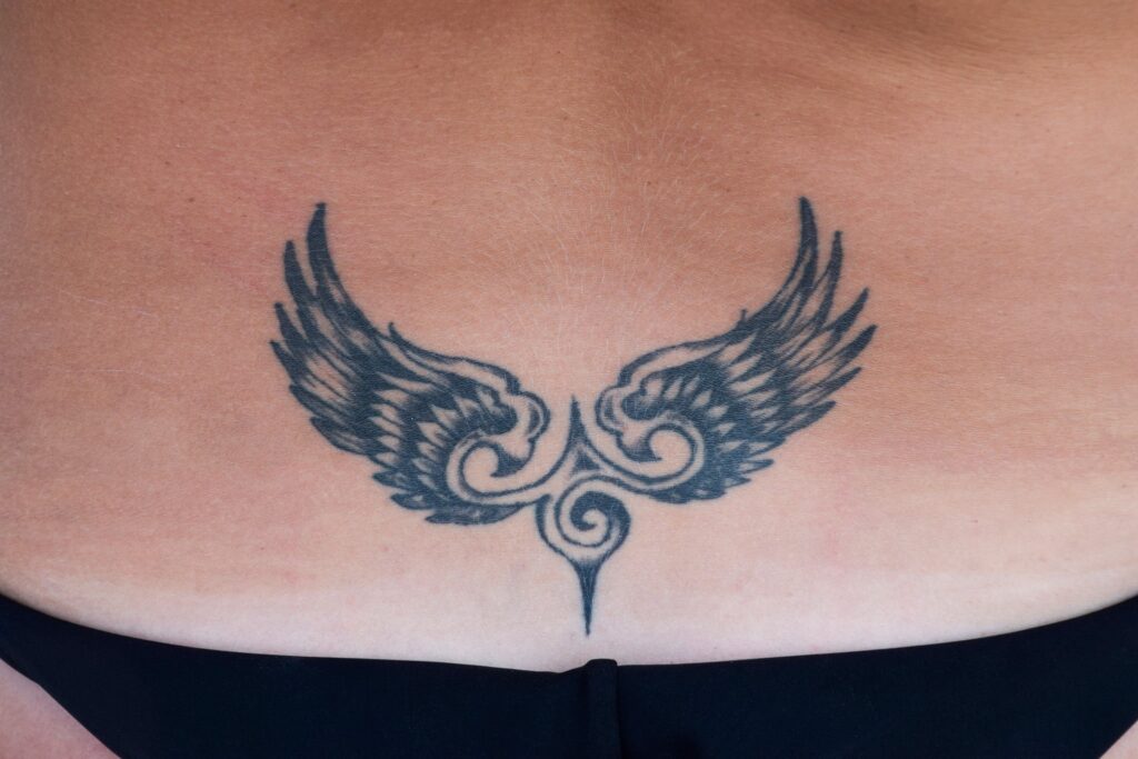 Wings tattoo on the angle for girls photo.