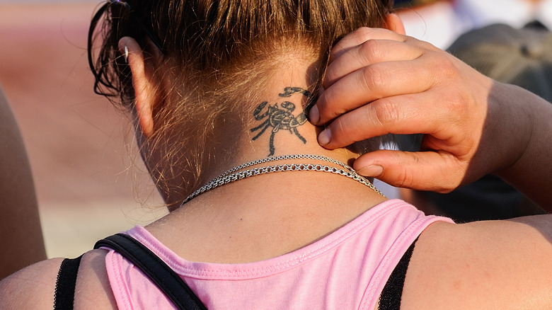 scorpion neck tattoo on girl neck